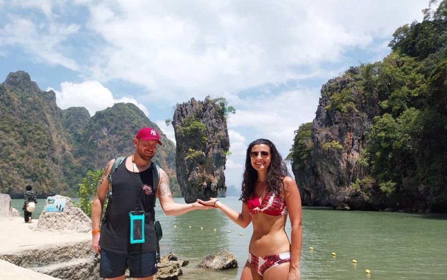 Two guests posing in front of the James Bond Island rock