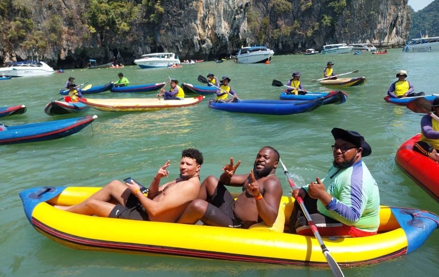 Guests in a kayak with a paddler in Phang Nga Bay