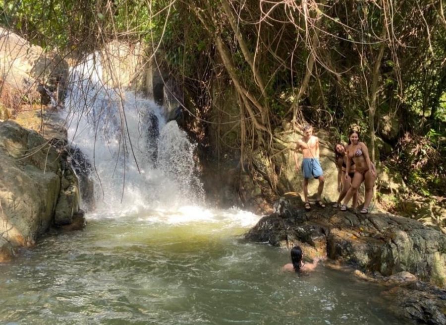 Guests at a waterfall pool in the jungle