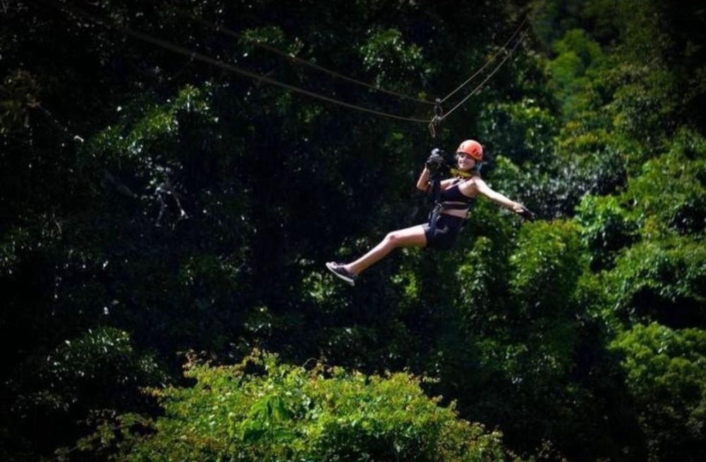 Guest riding a zipline above the forest in Koh Samui